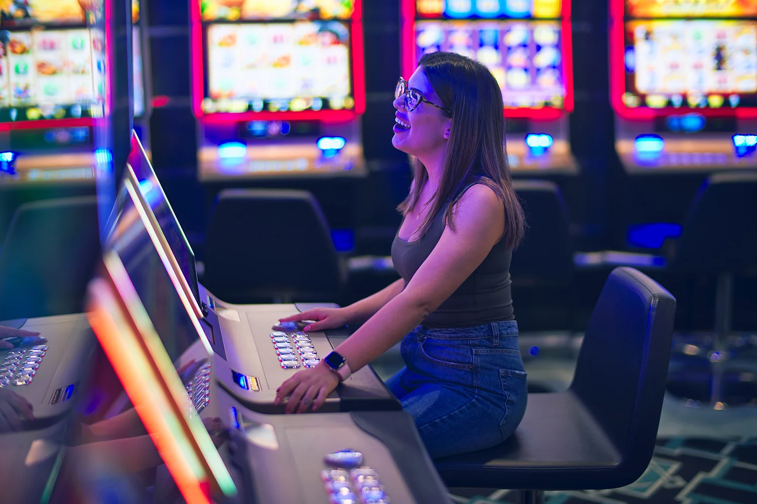 A lady happily playing slot game. She is immersed in the game, because the game’s intuitive interface and gaming experience.